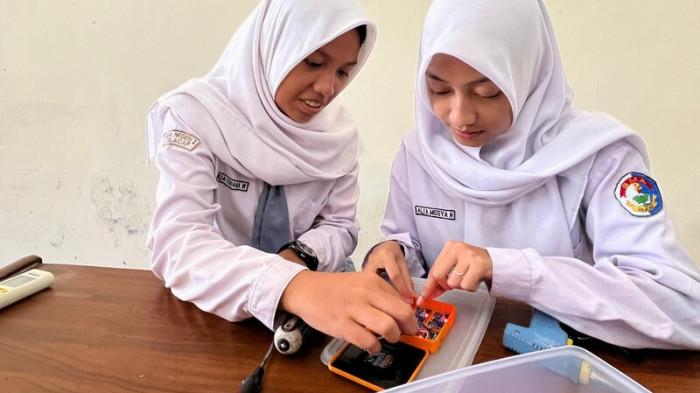 MERAKIT - Dua siswi SMA Negeri 2 Cilacap, Alya Meisya N dan Felda Triana W, tengah merakit alat inovasi Ompreng Pendeteksi Keracunan MBG karya mereka, Selasa (30/9/2025). Alat ini bisa mendeteksi kandungan makanan MBG yang dapat memicu keracunan saat dikonsumsi.