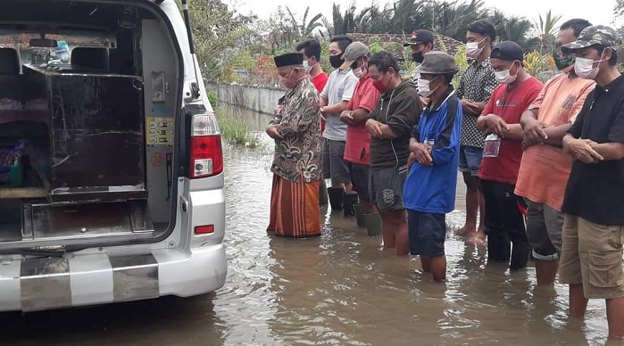 foto-keluarga-dan-petugas-melakukan-salat-jenazah-di-tengah-banjir-saat-pemakaman-pasien-covid.jpg