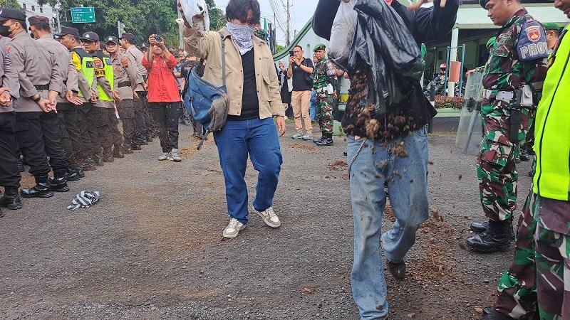 mahasiswa-banyumas-menebar-kotoran-sapi-dalam-demo-tolak-pengesahan-uu-tni-di-depan-kodim-banyumas.jpg