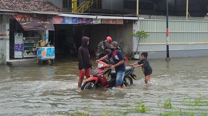 tiga-anak-mendorong-motor-mogok-akibat-banjir-di-muktiharjo-raya-kota-semarang-jumat-522021.jpg