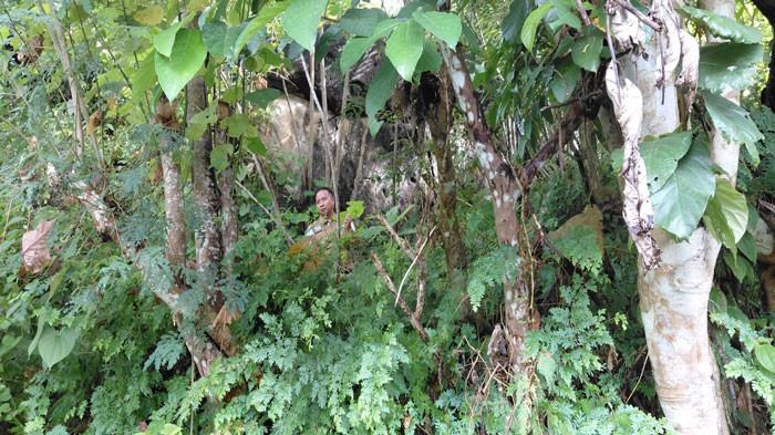 BATU BESAR - Personel polisi menunjukkan batu besar di lereng Bukit Tengkorak Anambas yang berpotensi longsor, baru-baru ini. Foto dok.Syamsir untuk Tribun Batam