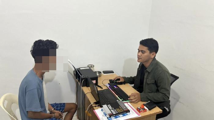 DIPERIKSA PENYIDIK - Tersangka AP (20) saat diperiksa di ruang penyidik Unit Reskrim Polsek Sagulung Batam, Selasa (13/1/2026)