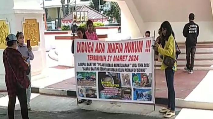 KASUS KEMATIAN ANAK DI BATAM - Aksi damai Amir dan Mugi, pasangan suami istri di Batam depan kantor DPRD Batam, Kamis (7/8/2025). Sudah setahun lebih mereka berharap keadilan terkait kematian anak mereka yang belum menemui titik terang. Mereka berharap DPRD Batam bisa melaksanakan rapat dengar pendapat (RDP).