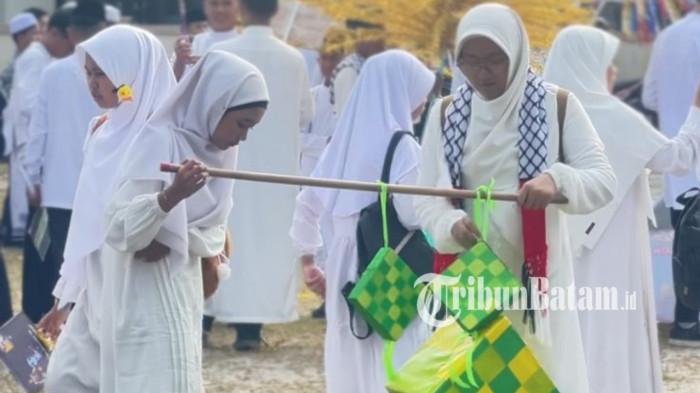 SAMBUT RAMADAN - Zhifa dan Putrin tampak memikul alat peraga ketupat yang mereka buat. SIT Insan Cendikia dan Ponpes Baitul Qur'an menggelar pawai menyambut Ramadan 1447 Hijriah di Dabo Singkep, Kabupaten Lingga, Provinsi Kepri, Senin (16/2/2026).