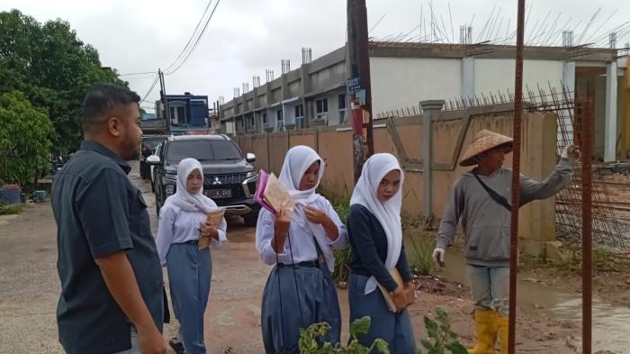 BANJIR DI BATAM - Anggota Komisi III DPRD Batam, Risky Aji Perdana saat meninjau lokasi Banjir di RT 07/RW10, Kelurahan Tiban Indah, Kecamatan Sekupang, Kota Batam, Provinsi Kepulauan Riau (Kepri), Senin (15/12/2025).