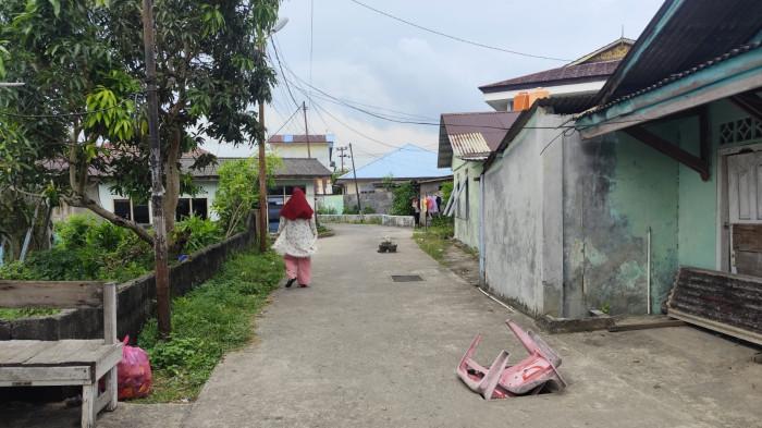 JALAN DI TANJUNGPINANG - Dua besi penutup drainase selokan atau parit jalur air di Lorong Skip I hilang. Warga pasang kursi plastik dan pot bunga beralas papan menutup lubang menganga, Selasa (11/11/2025).