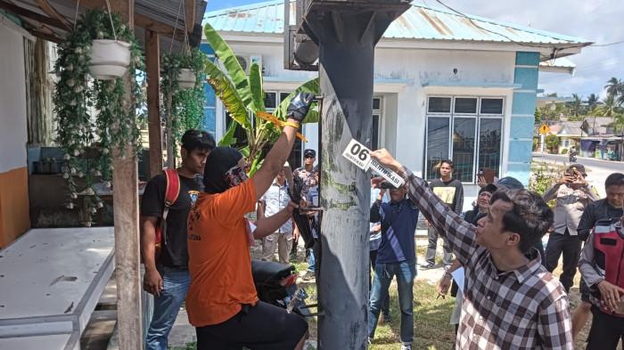 REKONSTRUKSI PEMBOBOLAN TOKO EMAS DI NATUNA - Tersangka DS saat memperagakan dirinya memanjat besi baliho di dekat pos polisi lalu lintas, sebelum melewati empat ruko di samping lokasi, hingga mencapai lantai dua toko Mas Safari, dalam rekonstruksi kasus pembobolan toko emas di Natuna, Sabtu (25/4/2026).