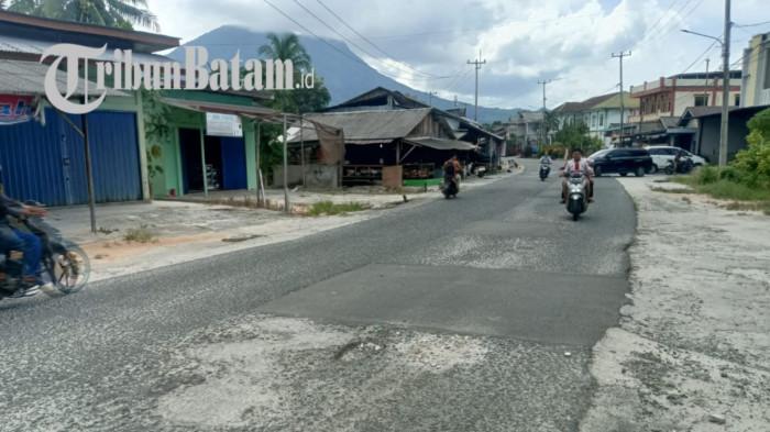 JALAN BERLUBANG - Kondisi jalan berlubang di Jalan HR Soebrantas, Kelurahan Bandarsyah, Kecamatan Bunguran Timur, Kabupaten Natuna, Senin (8/6/2026). Dinas PUPR Natuna memastikan ruas jalan ini belum bisa diperbaiki tahun ini, dan diprioritaskan pada 2027, akibat keterbatasan anggaran.