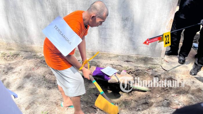 REKONSTRUKSI - Zakaria alias Jaka (43), tersangka pembunuhan terhadap istri siri di Dabo Singkep, Kabupaten Lingga, Provinsi Kepri, saat memperagakan penguburan usai habisi nyawa istri saat rekonstruksi, Senin (18/5/2026).