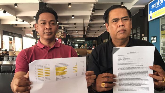 UANG NASABAH HILANG - Heru Gunawan (baju merah) didampingi pengacaranya Robby Batubara dari RBA Lawyers memperlihatkan bukti transaksi dan laporan ke polisi setelah ia menjadi korban kejahatan siber, Sabtu (11/4/2026). Uang sebesar Rp1,8 Miliar untuk membayar hak keuangan karyawannya raib diduga gegara layanan BizChannel CIMB Niaga Tbk.