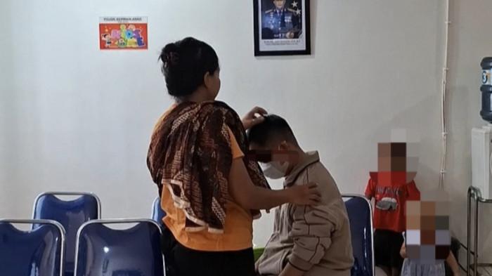 DAMPINGI SUAMI - Istri oknum guru SMKN 1 Batam dampingi sang suami saat pemeriksaan di Mapolsek Batuaji, Batam, Selasa (10/2/2026)