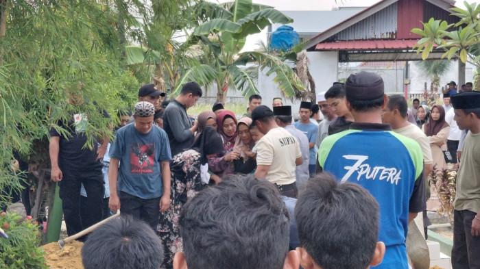 WARGA KARIMUN TEWAS TENGGELAM - Istri Handoko (45) sembari menggendong anaknya yang masih balita ikut proses pemakaman sang suami di TPU Teluk Air, Kabupaten Karimun, Provinsi Kepulauan Riau (Kepri), Minggu (3/5/2026) sore. Handoko tewas tenggelam di Pantai Pelawan saat mencoba menyelamatkan anaknya.