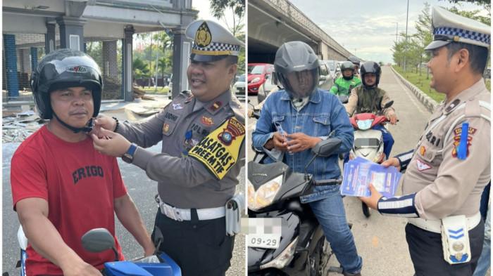 Personel Satlantas Polresta Barelang bagikan brosur himbauan dan berikan helm gratis kepada pengendara di Batam, Selasa (18/11/2025)