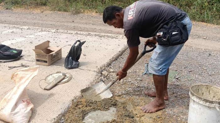 KORBAN KECELAKAAN DI LINGGA - Sosok Narles (50), saat menyemen jalan berlubang menuju Desa Marok Tua, Singkep Barat, Kabupaten Lingga, Provinsi Kepri, beberapa waktu lalu. Ia diketahui mengalami kecelakaan, saat sepeda motor yang ia kendarai menabrak pikap terparkir mogok di jalan Desa Berindat, Kecamatan Singkep Pesisir, Sabtu (6/9/2025) malam.