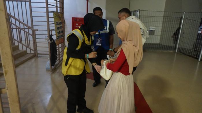 Steward perempuan sedang memeriksa barang penonton sebelum masuk ke Stadion Manahan untuk menyaksikan pertandingan BRI Super League.