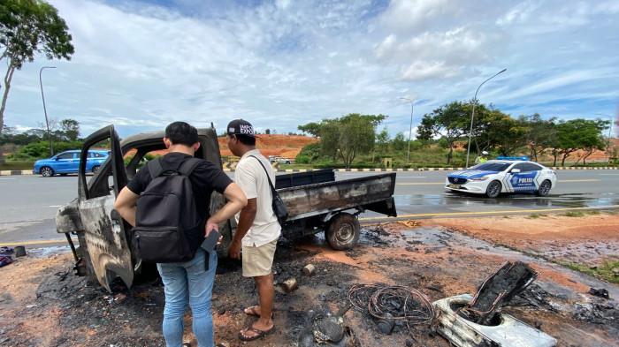 PIKAP TERBAKAR - Sugianto (kaos putih) melihat mobil pikap ditumpanginya gosong di ruas Jalan Hang Tuah, Nongsa, Batam, Sabtu (9/5/2026). Pikap itu sebelumnya angkut AC dan perlengkapan lainnya