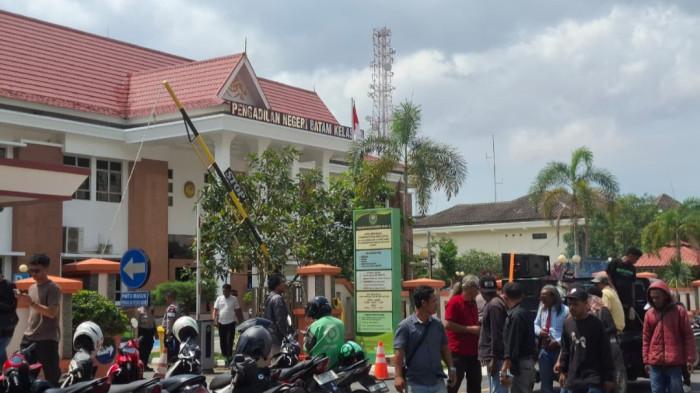 UNJUK RASA - Puluhan warga yang tergabung dalam Aliansi Masyarakat Peduli Kota Batam menggelar aksi unjuk rasa di depan Pengadilan Negeri (PN) Batam, Rabu (3/6/2026).