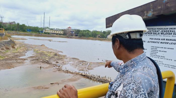 WADUK KEPRI  - Pjs Kasubag Produksi PDAM Tirta Kepri, Abdur Razak menunjukkan kondisi Waduk Sei Gesek yang mengalami penyusutan, Kamis (12/2/2026).