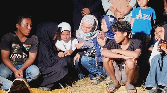 PEMAKAMAN - Wulan (14) (kerudung putih), anak korban pembunuhan di Bintan Timur didampingi keluarga saat berada di TPU Kijang, Kecamatan Bintan Timur, Kabupaten Bintan, Provinsi Kepri, Jumat (7/11/2025).