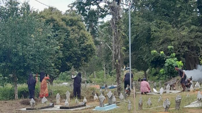 GOTONG-ROYONG - Warga Kelurahan Alai, Kecamatan Ungar, Karimun, dari kalangan ibu-ibu juga mengikuti kegiatan gotong royong di area pemakaman, Jumat (21/11/2025)