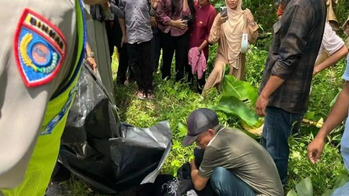 KECELAKAAN MAUT -- Warga bersama polisi mengevakuasi korban kecelakaan lalu lintas di Jalan Lintas Komering, Desa Rasuan, OKU Timur, Minggu (22/3/2026), melibatkan sepeda motor yang diduga menghantam lubang hingga penumpangnya terpental. Dua penumpang, seorang ibu muda dan balita, tewas setelah diduga tertabrak kendaraan lain yang melarikan diri.