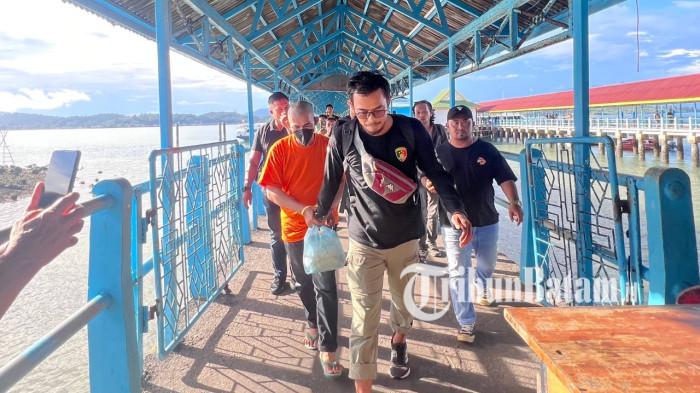 PEMBUNUHAN DI LINGGA - Zakaria alias Jaka (43), tersangka pembunuhan istri di Dabo Singkep, Kabupaten Lingga, Provinsi Kepulauan Riau (Kepri) digiring saat tiba di Pelabuhan Jagoh, Selasa (12/5/2026) sore. Ia jadi pusat perhatian saat tiba di sana.