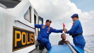 Personil-Satpolairud-membagikan-dan-menancapkan-bendera-merah-putih-di-atas-kapal-nelayan.jpg
