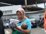 PMI-yang-turut-di-deportasi-Nur-Rohman-menggendong-sang-bayi-tiba-di-Pelabuhan-Batam-Center.jpg