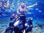 wisatawan-berpose-di-atas-motor.jpg