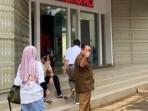 Kepala-Desa-Cikuda-AS-saat-mendatangi-Polres-Bogor-di-Cibinong.jpg