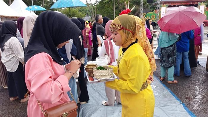 NYIRE MASSAL - Aksi tradisi menyirih atau nyire massal secara serentak pada Pembukaan Festival Budaya Napak Sire Belitung 2026 di Pantai Tanjung Pendam, Kecamatan Tanjungpandan, Jumat (22/5/2026). Aksi ini diharapkan menjadi daya tarik dan pemantik pariwisata budaya untuk mendongkrak kembali kunjungan wisatawan ke Pulau Belitung.