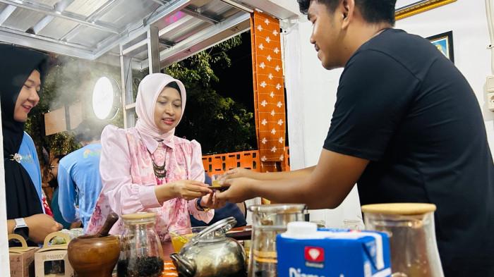 Salah satu pelaku UMKM Tea House Teras Manggar memberikan minuman jahe hangat kepada GM PLN Babel, Ira Savitri yang di masak menggunakan kompor listrik bantuan TJSL PLN Babel saat mengunjungi tenant UMKM dalam acara peresmian New Teras Manggar.