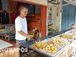 20220311-yansen-saat-mengangkat-gorengannya-di-tokonya.jpg