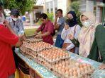 20220325-pembeli-saat-melihat-telur-yang-dijual-di-pasar-tani-manggar.jpg