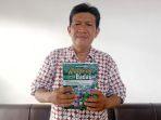 20240516-Penulis-Haril-M-Andersen-tunjukkan-buku-karya-terbarunya-bertajuk-Kampong-Badau.jpg