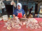 Penjual-daging-ayam-sedang-membersihkan-potongan-daging-ayam-sebelum-dijual.jpg