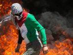 seorang-demonstran-berjalan-dekat-kobaran-api-saat-bentrok-dengan-pasukan-israel-oke.jpg