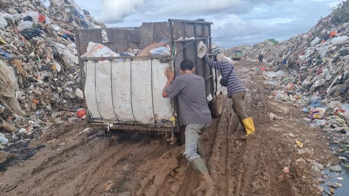 KELUHAN DRIVER SAMPAH - Kendaraan angkutan sampah saat terprosok kedalam lubang pada Jumat (21/11/2025). Driver angkutan sampah kembali keluhkan terkait kondisi jalan yang semakin parah di Tempat Pembuangan Akhir (TPA) Air Sebakul.