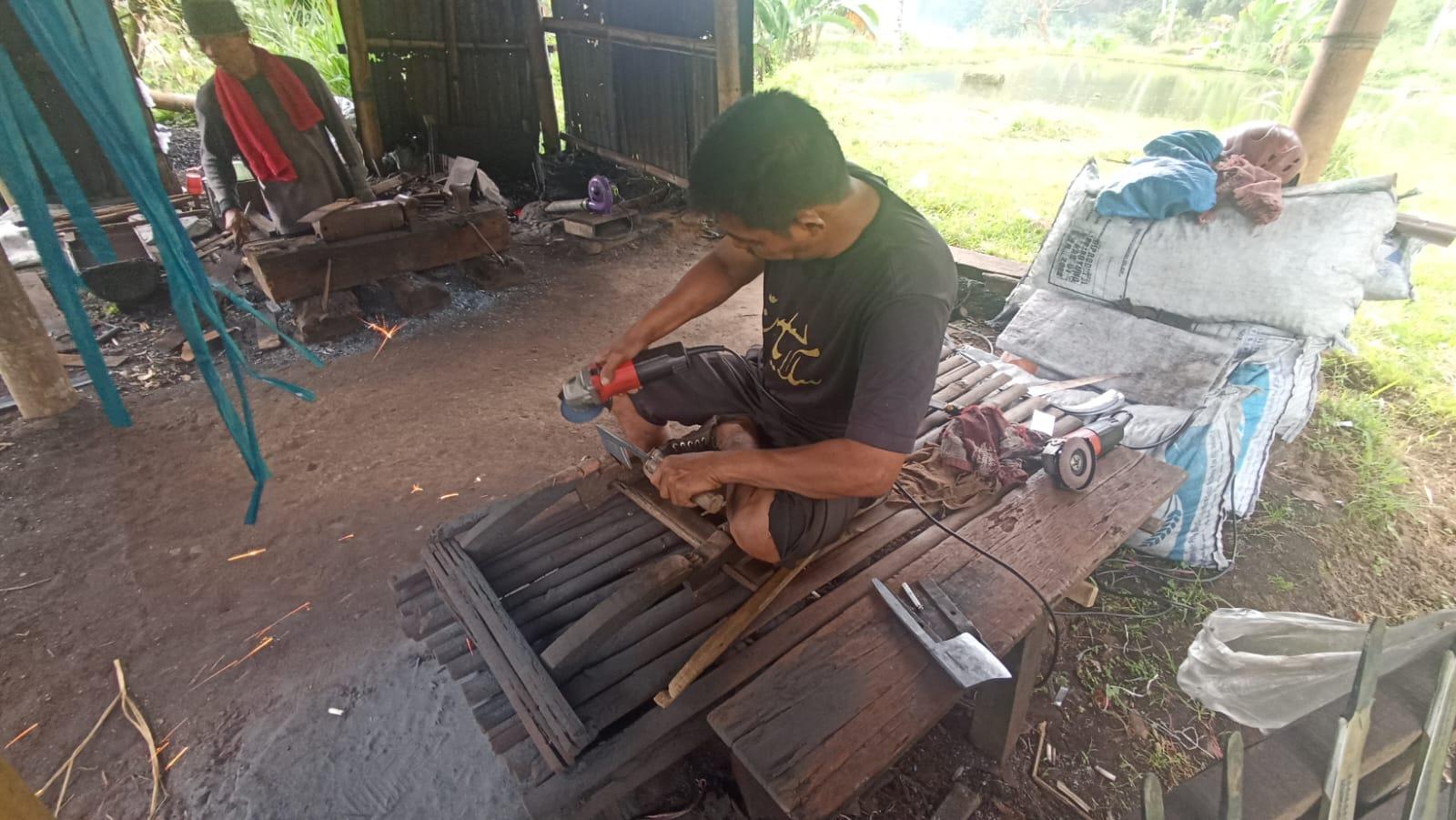 Pengrajin-pisau-merapikan-bentuk-kapak-tulang-dan-mengasahnya.jpg