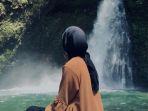 Seorang-wisatawan-sedang-menikmati-pemandangan-di-tempat-wisata-Air-terjun-Palak-Siring.jpg