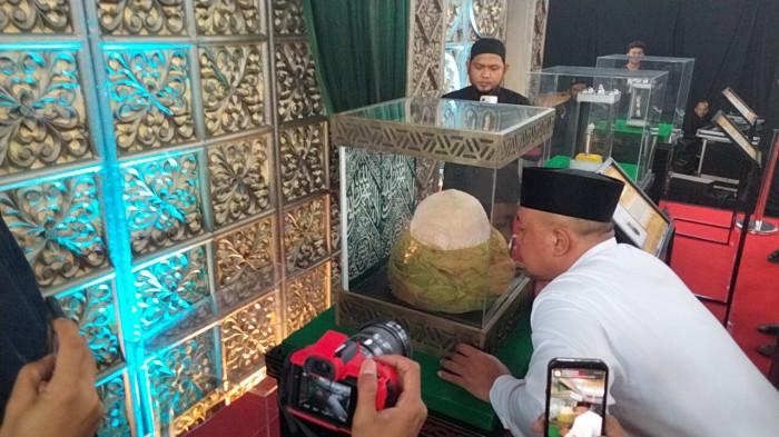PAMERAN DI PAKANSARI - Bupati Bogor Rudy Susmanto saat mencium sorban Rasulullah SAW dalam kotak kaca ketika membuka pameran artefak di GOR Laga Satria Pakansari, Kecamatan Cibinong, Kabupaten Bogor, Jumat (20/2/2026).