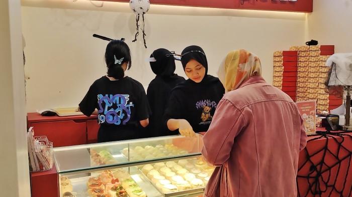 UMKM BOGOR - Karyawan Mave Douchi bOGOR tampak melayani pembeli. Pelayanan hangat dan cepat menjadi salah satu alasan pelanggan betah berkunjung untuk menikmati donat mochi dengan berbagai varian rasa kekinian.