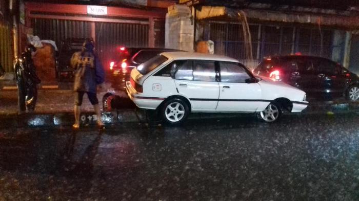 Hujan Deras, Tiba-tiba Mobil Nyangkut di Trotoar Simpang Tiga Empang Bogor