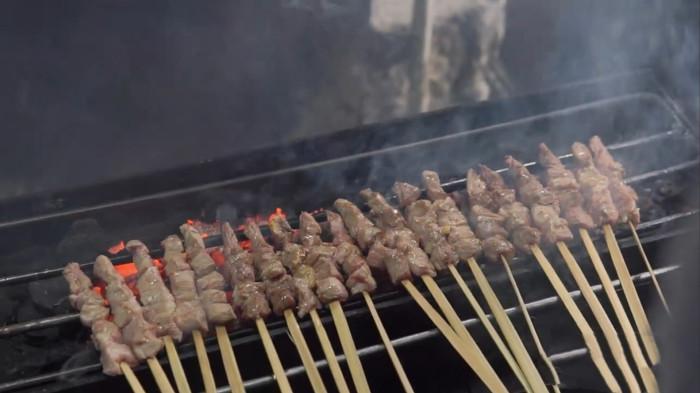 KULINER BOGOR - Sate Kambing Pak Rebing dibakar di atas bara arang. Proses pembakaran yang menghasilkan aroma khas ini adalah kunci yang membuat sate legendaris Empang Bogor, yang telah berdiri sejak 194
