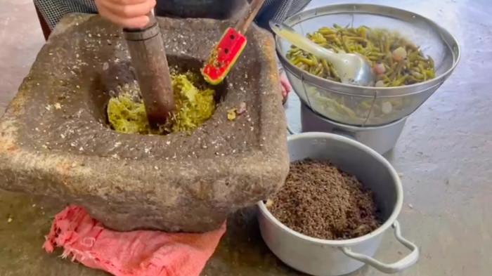UMKM BOGOR - Proses penumbukan sambal Tomburi dilakukan 100 persen manual tanpa blender, termasuk menumbuk bumbu di lumpang batu, untuk mempertahankan cita rasa otentik khas Batak.