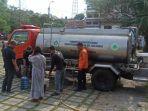 Anggota-BPBD-Kabupaten-Bogor-sedang-mendistribusikan-air-bersih-untuk-warga.jpg