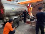 Anggota-BPBD-Kabupaten-Bogor-sedang-menyiapkan-armada-untuk-mendistribusikan-air-bersi.jpg