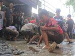 berebut-ikan-lele-di-kubangan-jalan-rusak.jpg