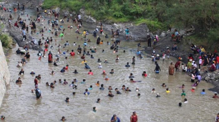 NGOBENG - Warga Desa Cijemit, Kecamatan Ciniru, Kuningan, dan sekitarnya, semringah saat mengikuti ngobeng alias tangkap ikan tanpa alat di saluran sungai desa tersebut.