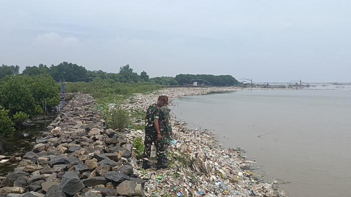 Potret tumpukan sampah sejauh mata memandang, mengikuti lekukan bibir pantai di Pantai Kesenden Cirebon. 